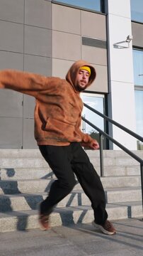 Full length shot of young man dancing hip hop on stairs against modern industrial building background freedom youth energy street culture vertical slow motion video stock