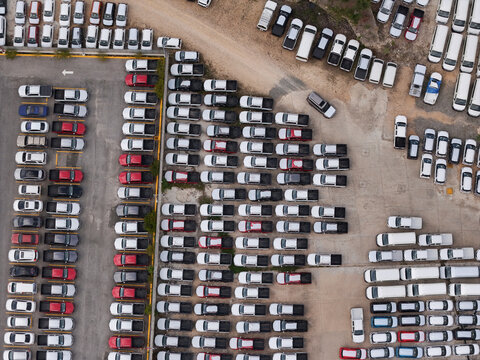 Aerial view of Avenida Isabel Aguiar showing rows of parked pickup trucks and vehicles in a storage lot in Santo Domingo, Distrito Nacional, Dominican Republic.