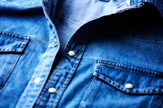 Close up of blue denim shirt with buttons. Soft focus.