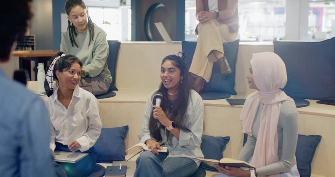 Facilitator offering microphone to Indian woman, consulting notes and answering question on steps