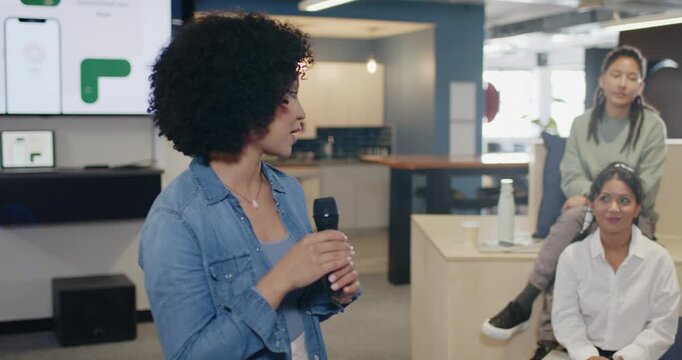Diverse coworkers watching host holding mic seeking input on steps, hijab peer speaking, copy space
