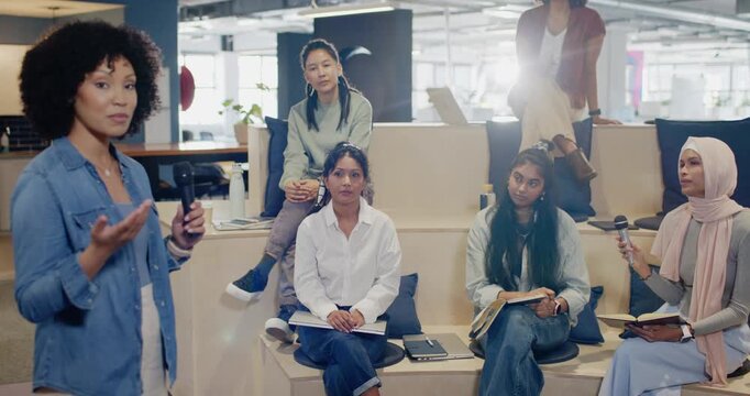 African American woman speaking at office kickoff with mic gesturing to invite questions