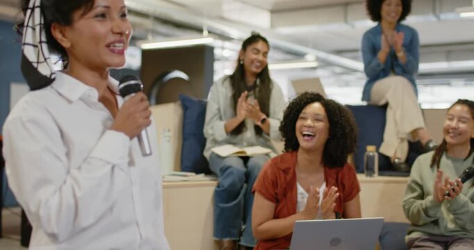 Indian woman host holding mic, opening and engaging team in office meeting with laptop, copy space
