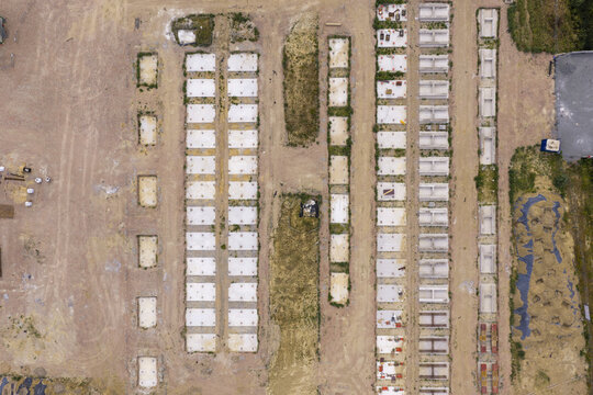 Aerial view of BESS construction site showing rows of concrete foundations and prepared ground for battery energy storage systems.