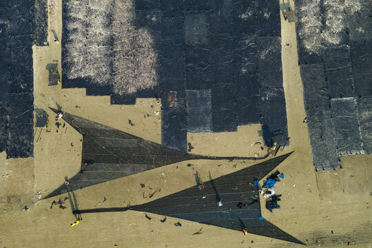 Aerial view of Gohira beach where fish are being dried on large black nets, with workers tending to the catch under the sun in Anwara, Chittagong Division, Bangladesh.