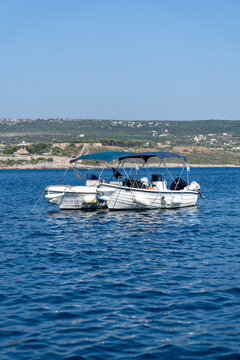 White motorboat with blue canopy moored