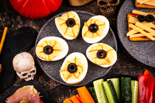 Halloween appetizers with pumpkin hummus deviled eggs and mummy snacks