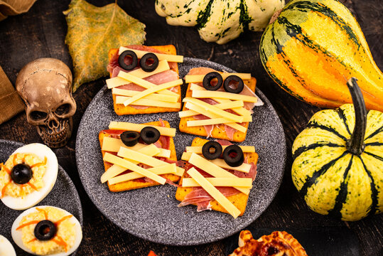 Halloween appetizers with pumpkin hummus deviled eggs and mummy snacks