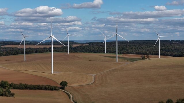vue a&eacute;rienne panoramique du parc &eacute;olien d'Ottange en Moselle. Les &eacute;oliennes en fonction ressortent sur un ciel bleu nuageux, au milieu des champs labour&eacute;s et entour&eacute;s de for&ecirc;ts. France 2026