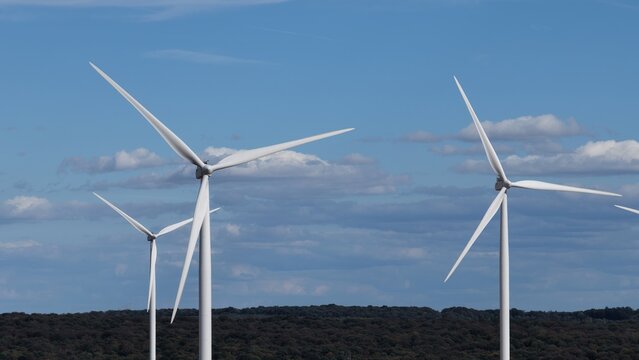 vue a&eacute;rienne en gros plan des &eacute;oliennes et du parc &eacute;olien d'Ottange en Moselle. Les pales et les nacelles blanches tournent sur un ciel bleu l&eacute;germent nuageux. Frrance septembre 2026 