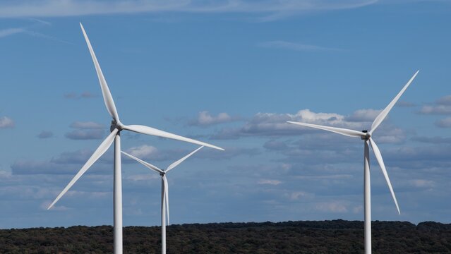 vue a&eacute;rienne en gros plan des &eacute;oliennes et du parc &eacute;olien d'Ottange en Moselle. Les pales et les nacelles blanches tournent sur un ciel bleu l&eacute;g&egrave;rement nuageux. France septembre 2026 