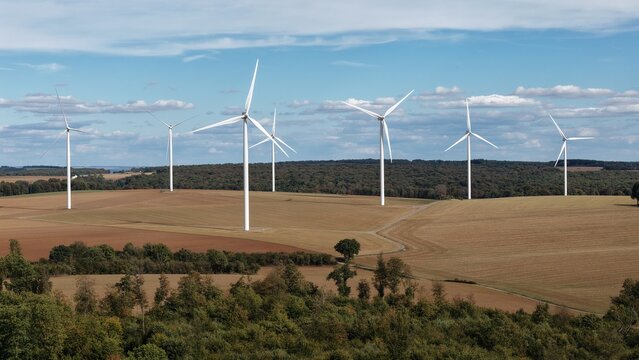 vue a&eacute;rienne panoramique du parc &eacute;olien d'Ottange en Moselle. Les &eacute;oliennes en fonction ressortent sur un ciel bleu nuageux, au milieu des champs labour&eacute;s et entour&eacute;s de for&ecirc;ts. France 2026