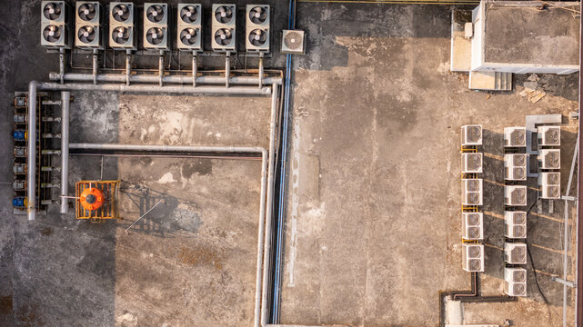 Aerial view of industrial rooftop with multiple air conditioning compressor units, ventilation pipes, and an orange tank in Klaten, Central Java, Indonesia.
