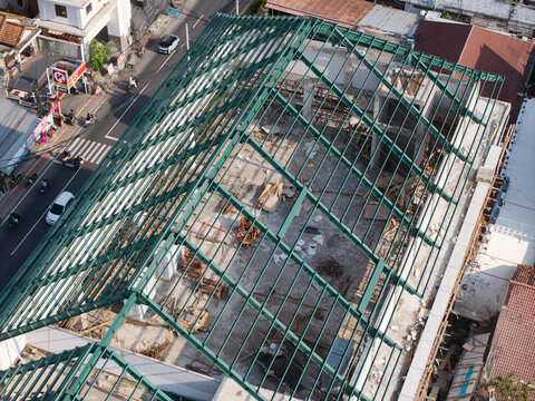 Aerial view of the Emergency Room of Wangaya Regional General Hospital construction site, featuring a green steel roof frame in Kecamatan Denpasar Utara, Bali, Indonesia.