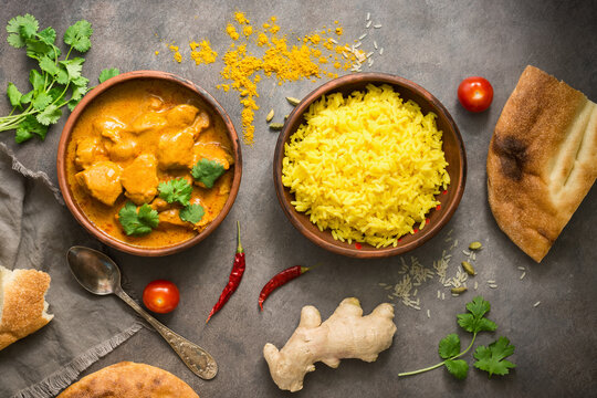 Indian food Chicken Tikka Masala with basmati rice on a dark grunge background, top view, flat lay.