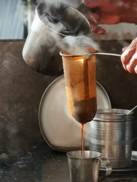 Traditional Southeast Asian coffee being poured through a long cloth filter bag, utilizing the classic Nanyang brewing technique to create a rich, smooth beverage.
