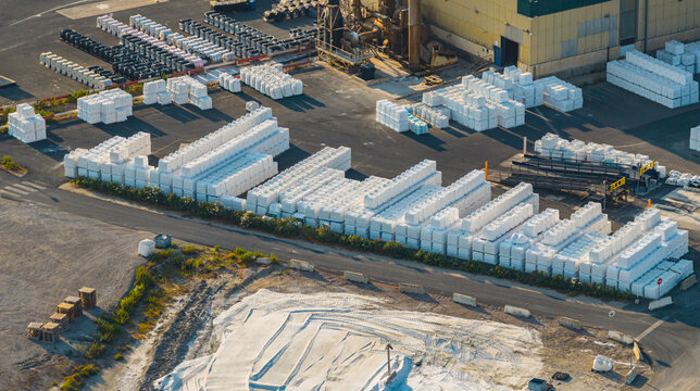 Aerial view of packaged sea salt products stacked across a large industrial storage and distribution yard in Aigues-Mortes, Occitanie, France.