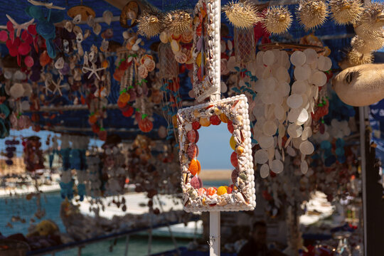 Colorful handmade decorations made from seashells displayed at a souvenir stall in Chania, Crete, Greece.