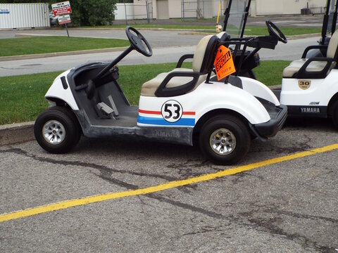 Gloucester, Ontario, Canada &ndash; July 12, 2026: A "white Yamaha golf cart with racing stripes, number 53, and a special price tag" parked outdoors on Rainbow Street .