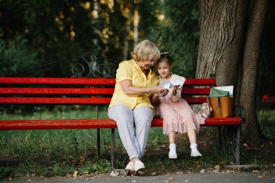 Grandmother and granddaughter reading letter together in park