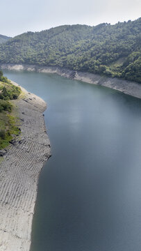Aerial view of Encoro de Belesar reservoir with terraced banks and surrounding green hills, Lugo, Lugo, Spain.