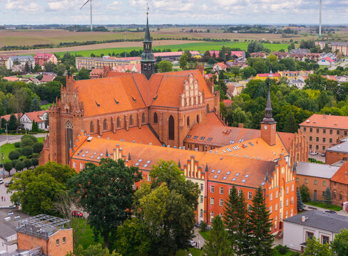 Aerial view of the Church of the Assumption of the Blessed Virgin Mary with red brick Gothic architecture and orange tiled roofs in Pelplin, Pomeranian Voivodeship, Poland.