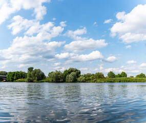 Panorama rzeki Odry w tle most lekko pochmurna pogoda, błękit nieba zieleń przy brzegu, pora letnia, Odra w odcinku województwa Opolskiego © mbugajsky