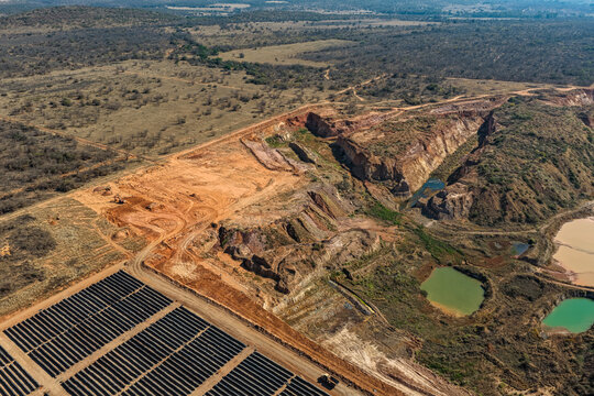Aerial view of a clay mining and brick production site featuring rows of drying bricks and contaminated water pools in the arid landscape of Polokwane, Limpopo, South Africa.