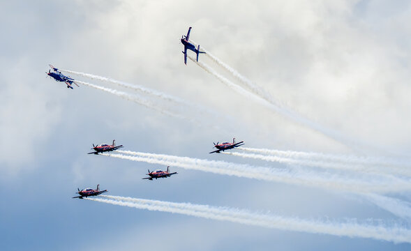 Singapore, Singapore - 21 February 2024: Aerial view of the Indonesia Jupiter aerobatic team performing a formation flight with smoke trails above the Changi Exhibition Centre during an airshow.