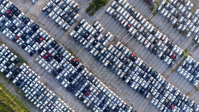 Piacenza, Emilia-Romagna, Italy - 01 August 2026: Aerial view of a car parking factory yard filled with rows of new vehicles parked in an industrial lot.