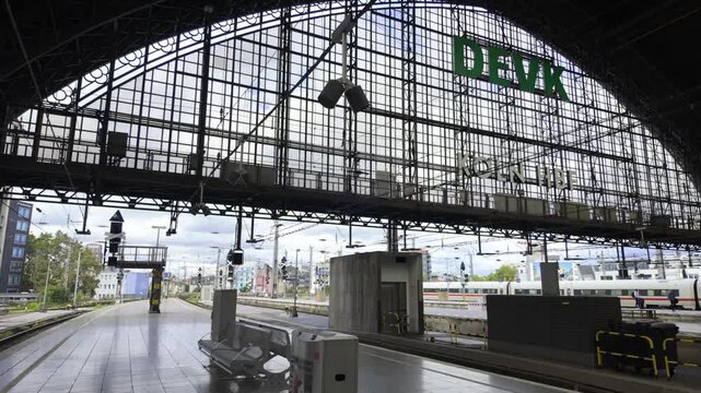 Intricate steel and glass arched roof of Cologne Central Station (K&ouml;ln Hbf) over train platforms in Germany.