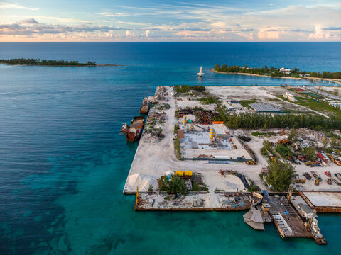 Nassau, The Bahamas - 16 September 2026: Aerial view of Arawak Cay featuring industrial port facilities, cargo ships docked at the pier, and turquoise Caribbean waters.