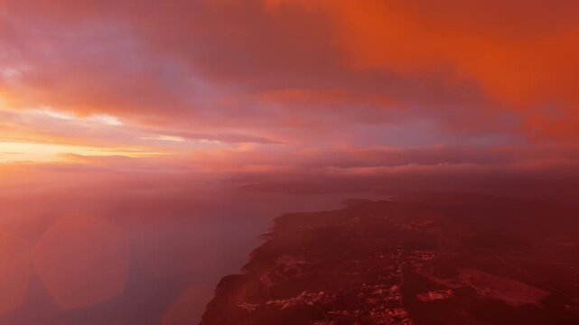 Golden sunset over ocean with dramatic clouds. Aerial view of sky and water at dusk. Vibrant orange nature landscape background, 4k