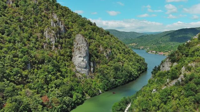 Aerial view of stone carved statue portrait of ancient dacian king Decebal. Sculpture located on shore of Danube River, Romania, 4k