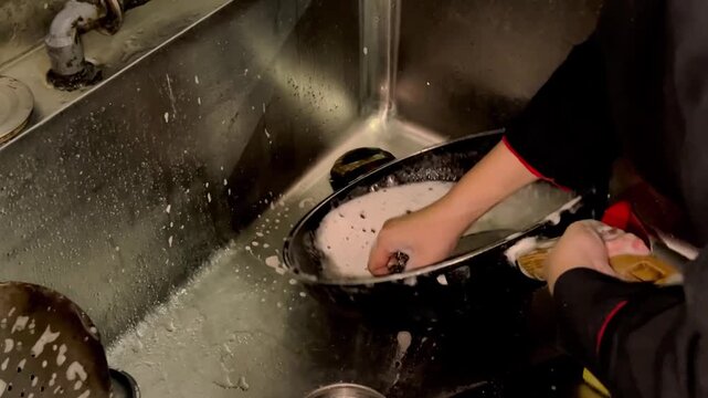 Person Washing Dishes by Hand in a Vintage Kitchen
