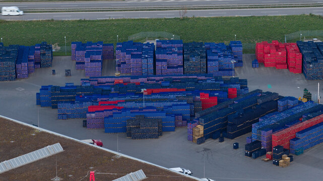 Munich, Germany - 11 September 2026: Aerial view of the Paulaner Brewery storage yard with stacks of blue and red plastic beer crates arranged in rows on the asphalt.