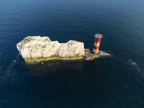 Isle of Wight, England, United Kingdom - 22 July 2021: Aerial view of The Needles lighthouse standing on a chalk stack surrounded by the deep blue waters of the English Channel.