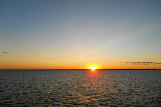 Golden sunset over coastal water with expansive sky