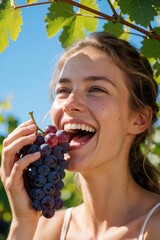 Obraz premium Smiling woman eats fresh grapes in sunny vineyard. She enjoys juicy fruit outdoors against blue sky. Healthy snack tasting experience. Summer harvest enjoyment.