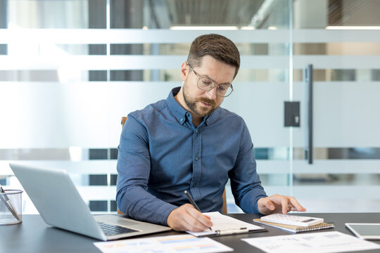 Financial planning and business analysis, professional man working with laptop and calculator in modern office for corporate accounting and budget management