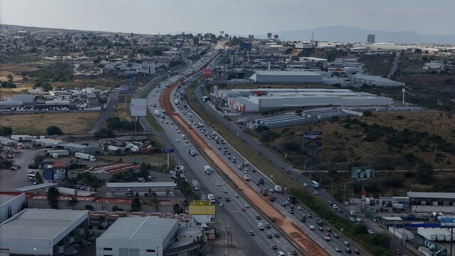 Santiago de Queretaro, Mexico - 14 September 2026: Aerial view of Mexican Federal Highway 57 with heavy traffic, industrial warehouses, and surrounding urban landscape.