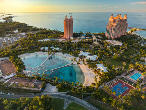 New Providence, The Bahamas - 03 January 2026: Aerial view of Paradise Island, featuring the pink towers of Atlantis resort, turquoise lagoons, lush gardens, and sports courts at sunset.