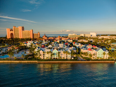 New Providence, The Bahamas - 03 January 2026: Aerial view of Paradise Island featuring the Atlantis resort with pink towers, colorful buildings, palm trees, and waterfront during the golden hour.