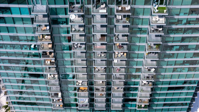 Los Angeles, California, United States - 13 September 2026: Aerial view of the modern glass facade of a high-rise building in the Miracle Mile district, featuring numerous balconies.
