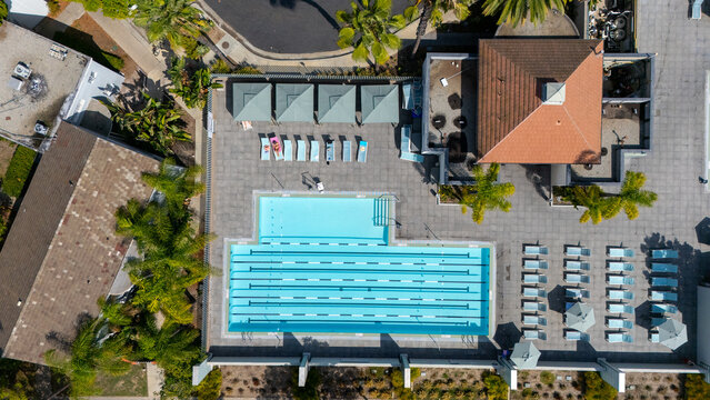 Los Angeles, California, United States - 13 September 2026: Aerial view of the swimming pool at Park La Brea Apartments, featuring turquoise water, lounge chairs, and palm trees.