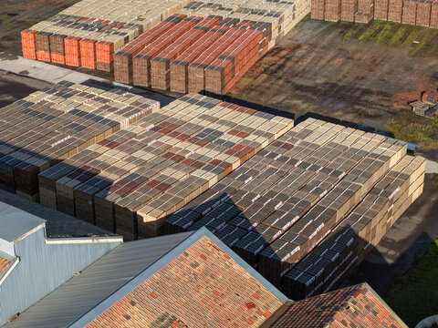 Scoresby, Australia - 09 September 2026: Aerial view of PGH Bricks Pavers Selection Centre, showing rows of stacked bricks and pavers in an industrial yard with a tiled roof building.