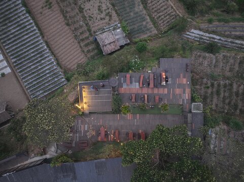 Kecamatan Getasan, Indonesia - 08 September 2026: Aerial view of Merbabu View Cafe with wooden decks, outdoor seating, and surrounding terraced agricultural fields in Jawa Tengah.