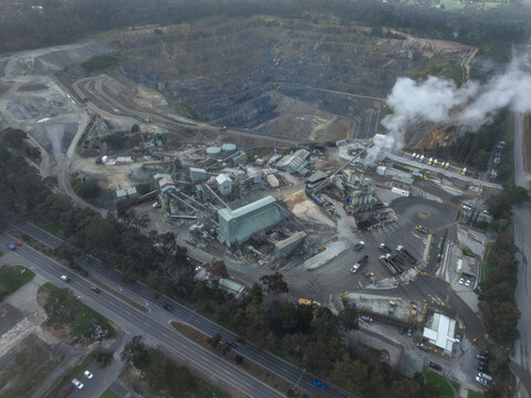 Montrose, Australia - 11 September 2026: Aerial view of Boral Asphalt quarry and processing plant with industrial machinery, trucks, and smoke rising from the facility.
