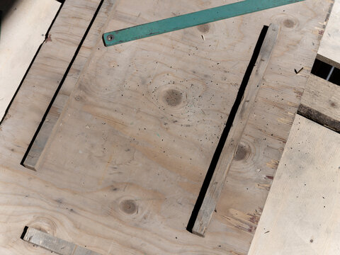 A tight top down frame of splintered pallet boards full of knots, the painted metal strip running out of the corner of the picture.