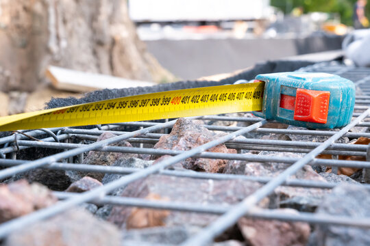 Yellow tape measure tool on steel wire gabion mesh at construction site